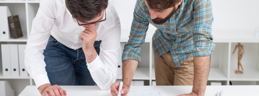 Two men standing near table and discussing current task. Concept of working together.