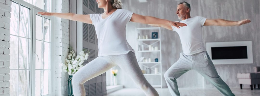 Senior couple is doing fitness training at home. Doing yoga together. Healthy lifestyle concept.