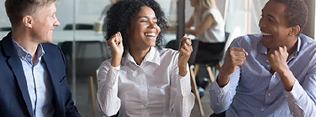 Colleagues Laughing with Each Other After Getting Employee Benefits in Loveland, Greeley, Longmont, Fort Collins, and Windsor